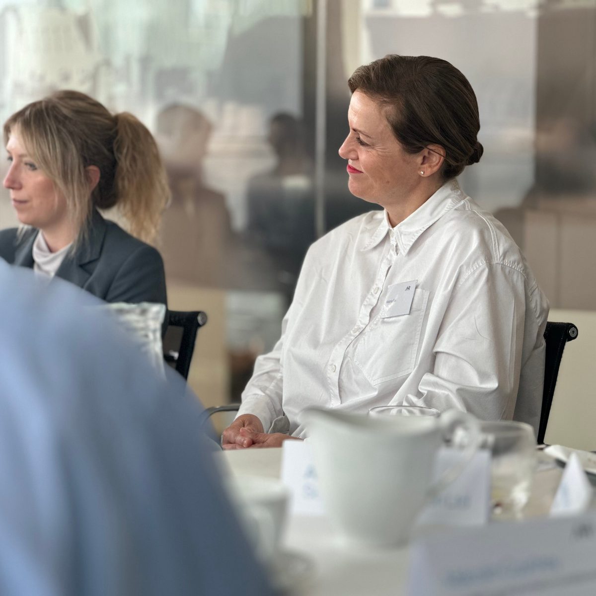 A candid of business development manager Melanie Fox smiling and listening to the roundtable discussion in a meeting room.