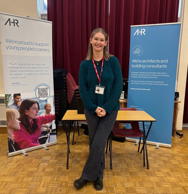 Building surveyor Nicole stood smiling in front of a stall at Broadoak School before speaking with students about career prospects.