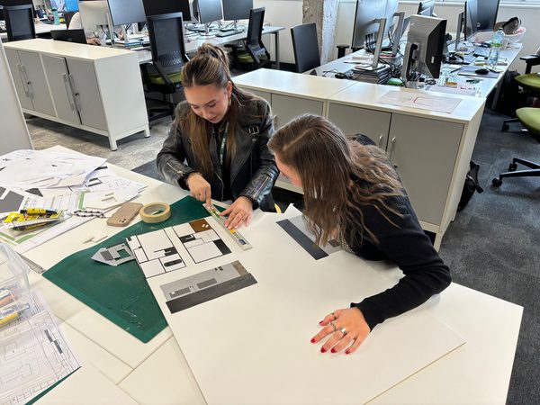 Architect Lynsey supporting a work experience pupil in the Glasgow office, looking at plans and drawings.
