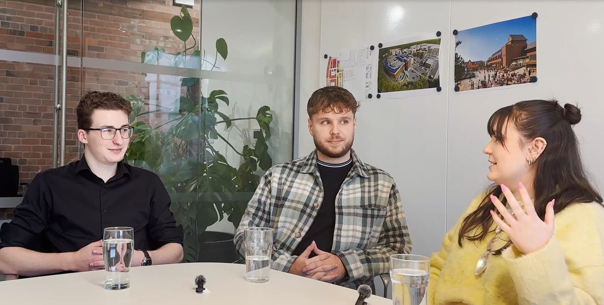 Three apprentices sit in a collaborative workspace discussing their experiences.