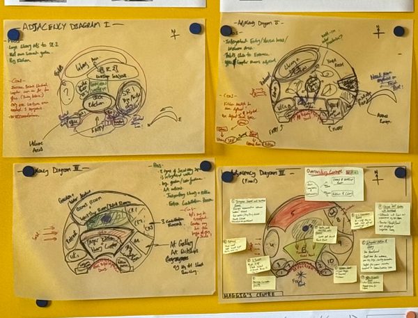 Four different sketches pinned up to a display board, each showing the adjacency diagrams for a proposed healthcare facility.