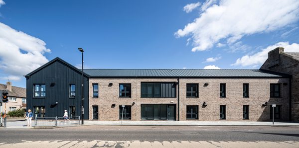 A wide shot of the exterior of 1 - 21 St Cuthbert's on a sunny day with pedestrians in the foreground.