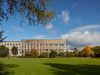 The complete exterior of the Faculty of Engineering and Architecture with bright bronze aluminium cladding, surrounded by verdant parkland.