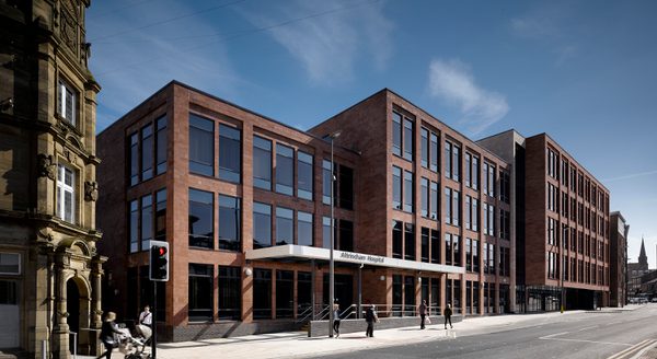 The redbrick exterior of Altrincham Hospital showing its on street position and extensive glazing.