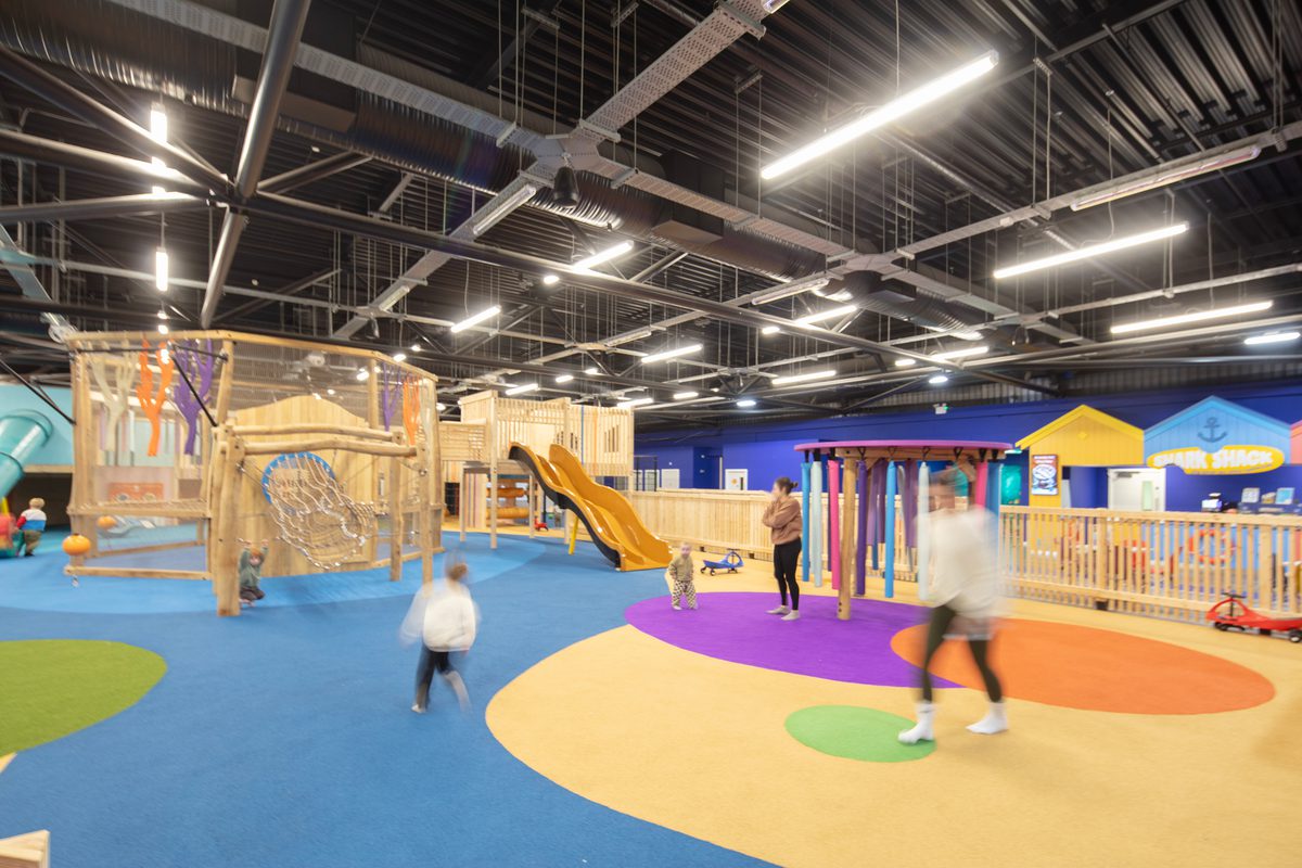 Children and adults interacting in the indoor play space at Barnsley Metrodome Adventure Reef.