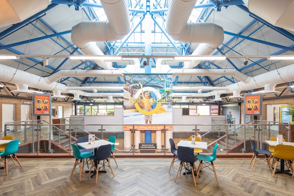Internal view across the cafe of the refurbished reception with natural daylight coming through the doors and windows.
