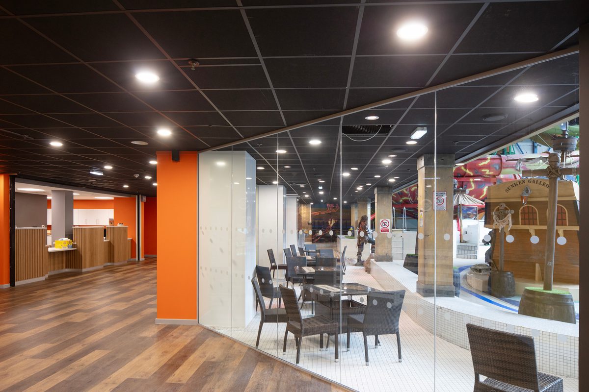 The bright reception area within the refurbished Barnsley Metrodome, with coloured columns and floor to ceiling windows providing views onto the swimming area.