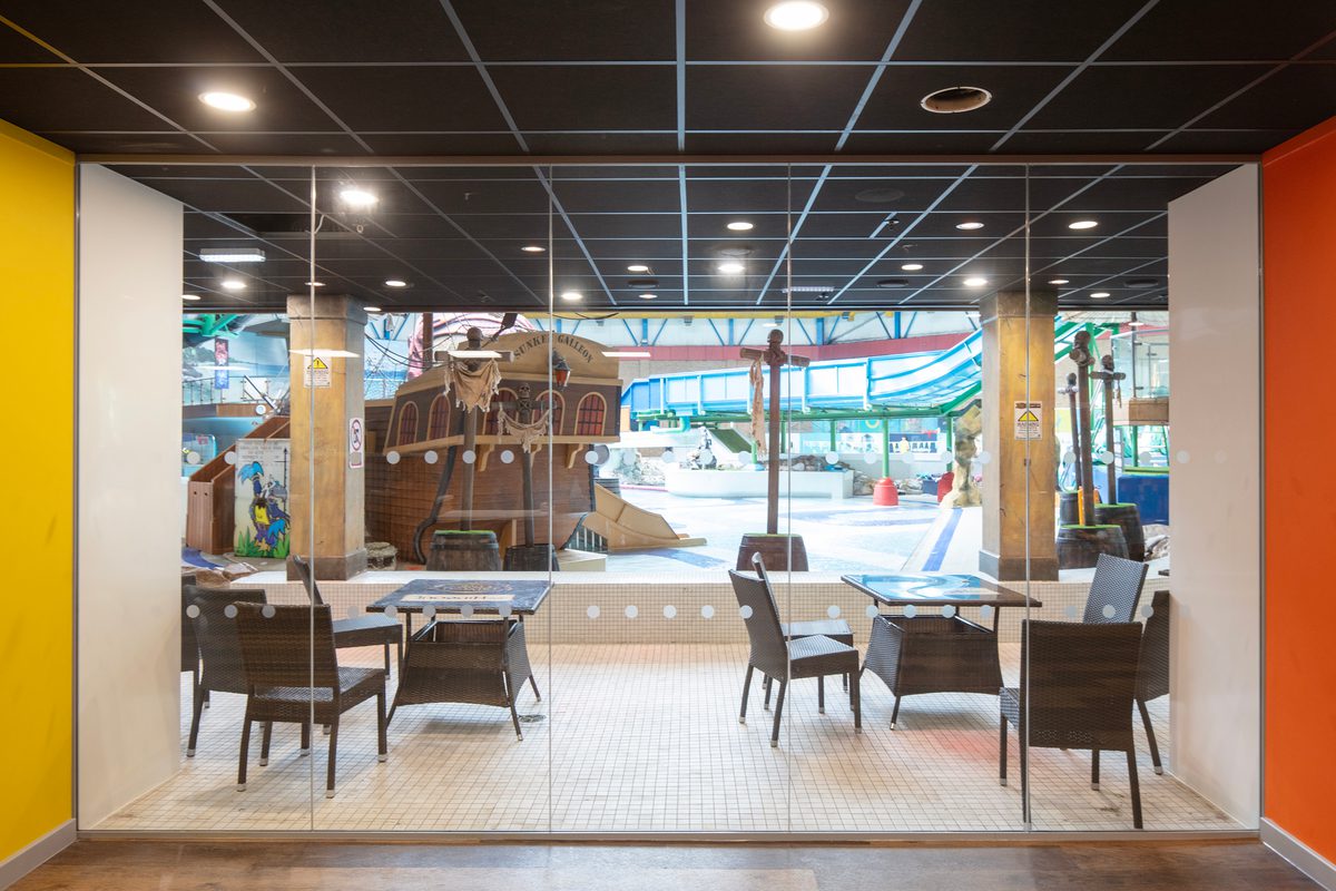 The bright reception area within the refurbished Barnsley Metrodome, with coloured columns and floor to ceiling windows providing views onto the swimming area.