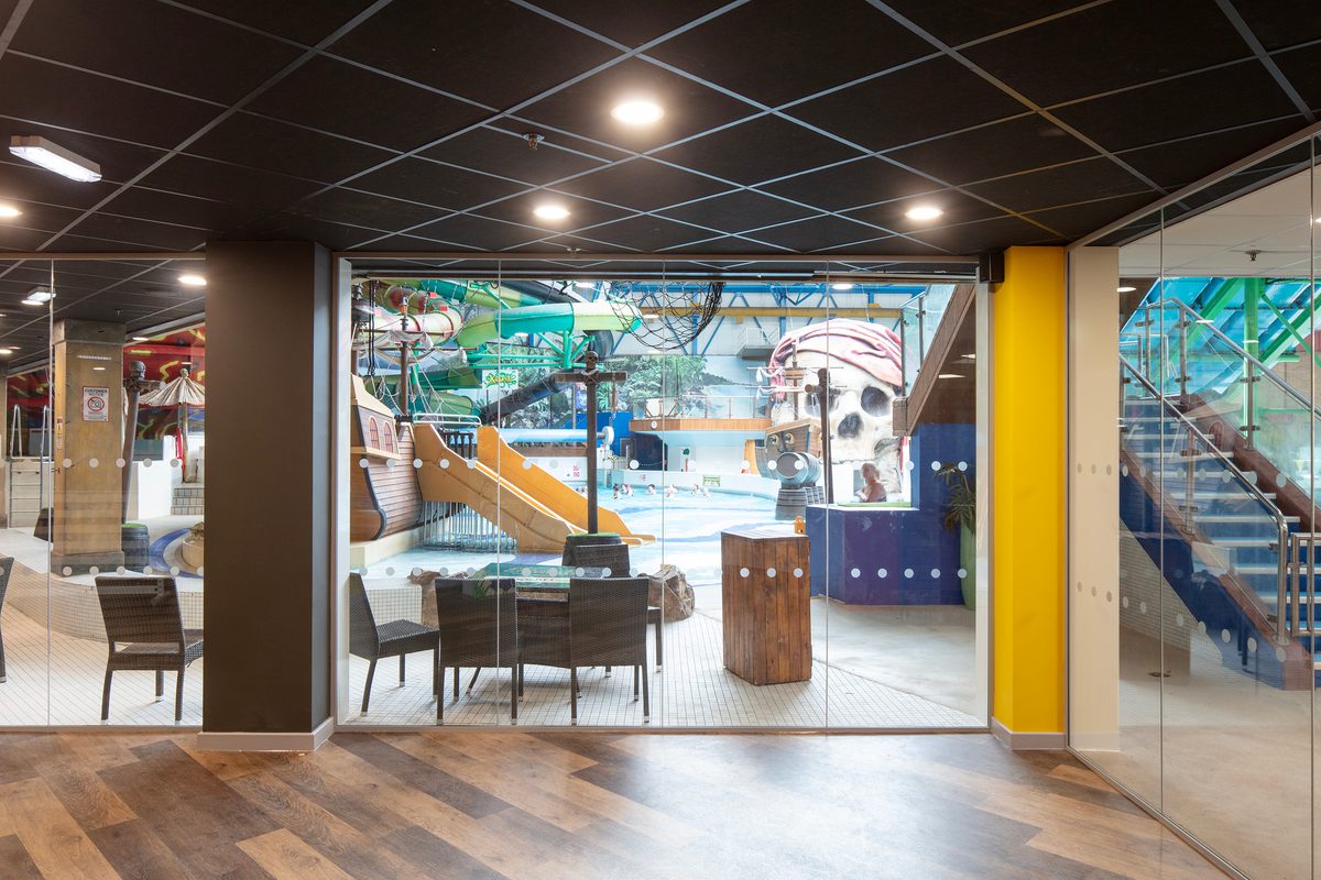 The bright reception area within the refurbished Barnsley Metrodome, with coloured columns and floor to ceiling windows providing views onto the swimming area.