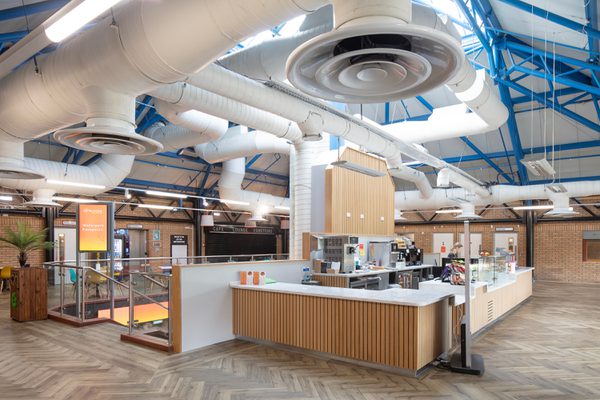 The café facilities within the bright reception area within the refurbished Barnsley Metrodome, with roof lighting and wooden detailing.