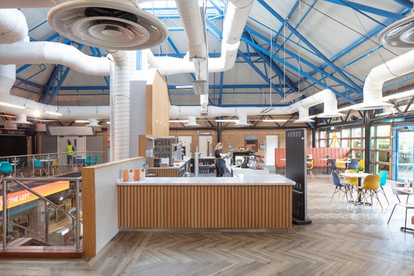 The café facilities within the bright reception area within the refurbished Barnsley Metrodome, with roof lighting and wooden detailing.