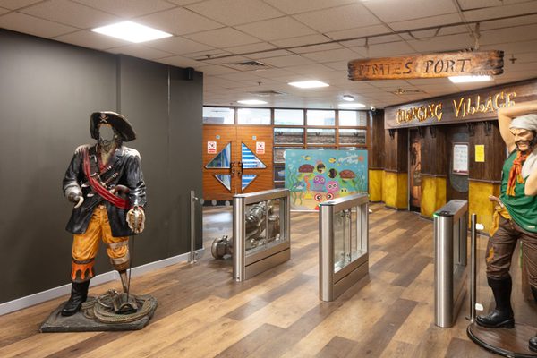 The security entrance gates within the interior of the refurbished Barnsley Metrodome reception, with novelty pirate themed props, signage and wall graphics.