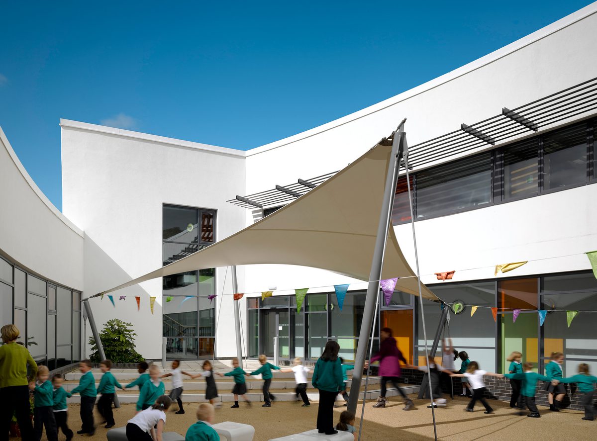 Children playing within the exterior courtyard playground of Cliffe Hill Primary School, part of Calderdale Council's property portfolio.