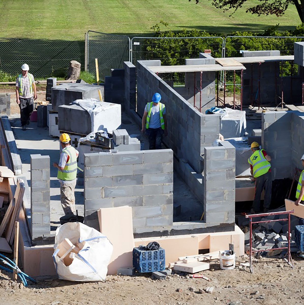 Construction workers on the building site of Cameron Close, with the houses under partial consturction.