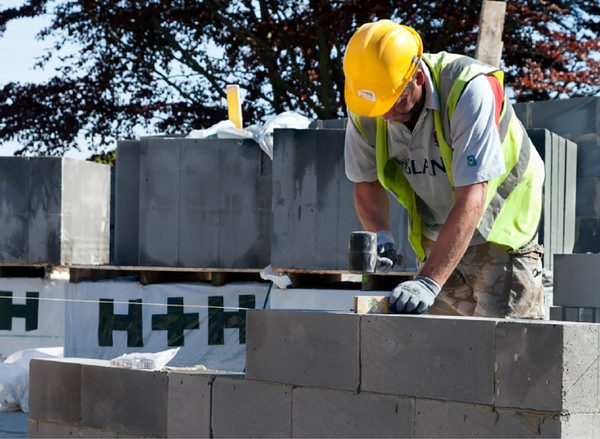 One construction worker levelling a breeze block wall, of one of the houses under construction within the Cameron Close residential development.
