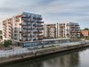 A wide shot of the two residential buildings sitting on the dockside location with active public realm in the foreground.