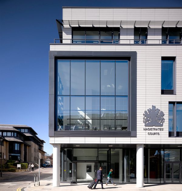 The prominent white exterior of Chelmsford Magistrates Court, with large windows and Her Majesty’s Courts Service logo detail.