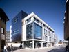 An exterior corner of Chelmsford magistrates court building, with high levels of glazing, white façade, with grey detailing.