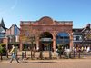 The preserved historic entrance of the Chester Northgate development, with people enjoying the new public realm in front.