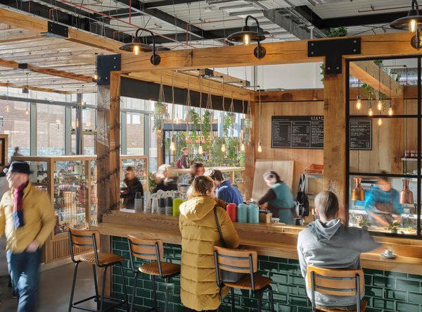 People enjoying one of the food and beverage vendors in the bright market hall, within the Chester Northgate development.