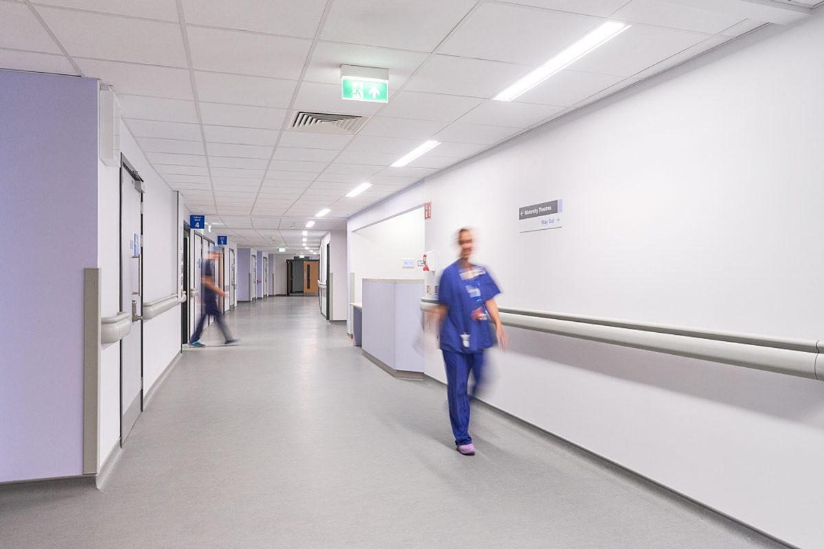 A staff member walking down the curved corridor.