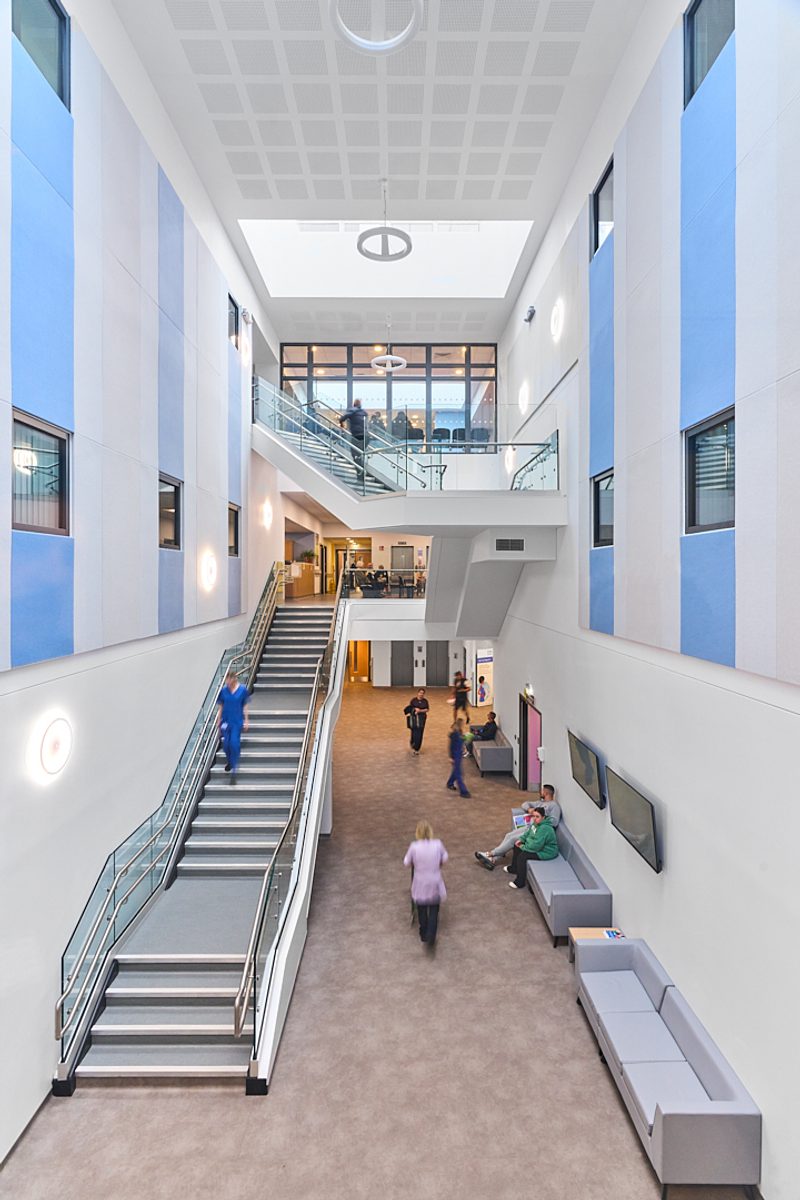 The entrance of the Women and Children's Building with people walking around the space.