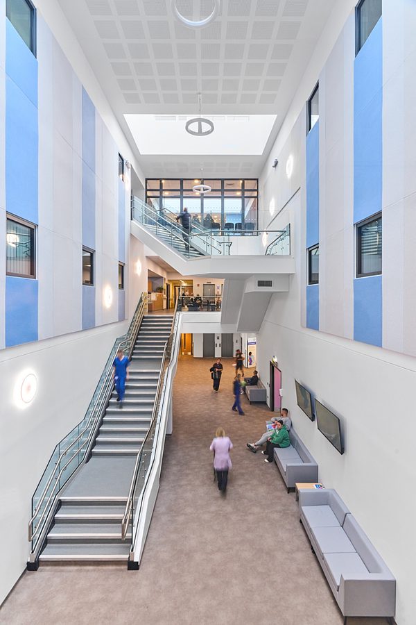 The entrance of the Women and Children's Building with people walking around the space.