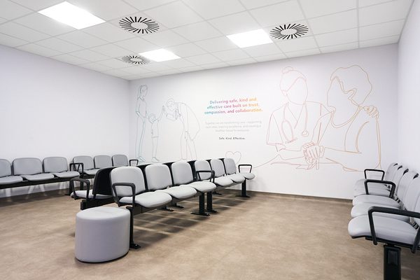 A waiting area inside the Women and Children's Building with a mural painting on the wall.