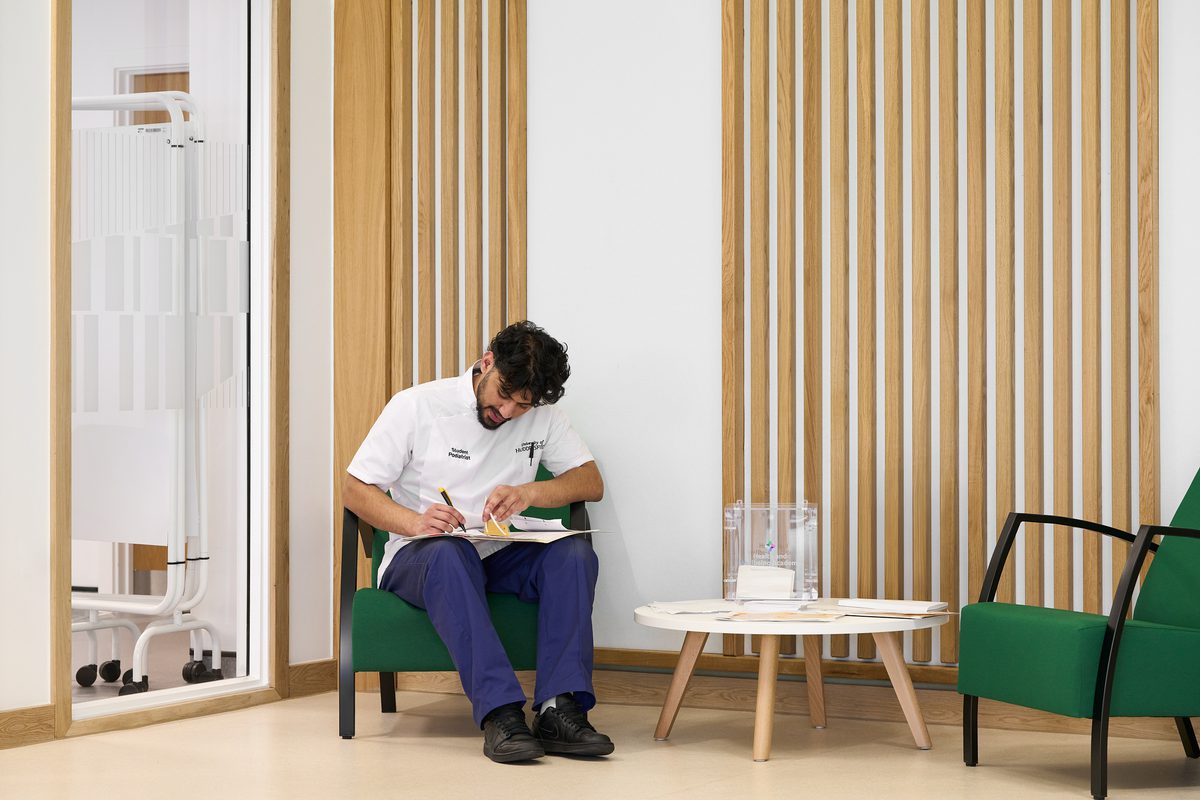 A member of staff sat down in the waiting area of the Podiatry clinic of the Daphne Steele Building.