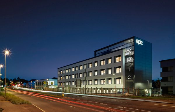 The exterior of Electronics and Photonics Innovation Centre (EPIC) at dusk, showing the large amount of windows and town centre location.