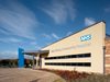 The front exterior face of East Riding of Yorkshire Community Hospital with sheltered entrance, planting in front, NHS logo and hospital name signage on the front of the hospital.