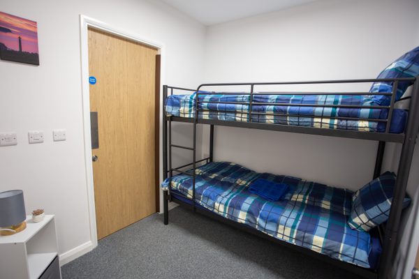 A dormitory within the East Whitby Primary School, Field Centre with door and bunk bed.