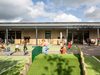 Children playing in the communal outdoor play area of Fair Isle Family Nurture Centre with green spaces and play equipment.