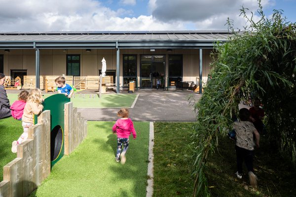 Fair Isle Family Nurture Centre outdoor play areas and nursery gardens, with children playing.