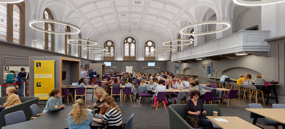 A bustling dining space in the refurbished Traders cafe in the Glenside Hub, with original stone features and windows and bright modern, bespoke lighting.