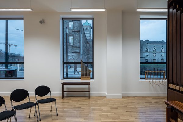 Recording space of the East Quad Building with single seating, timber detailing, instruments and views out to the historic campus.