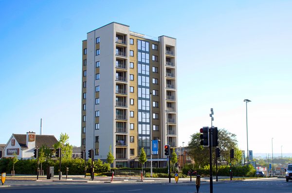 An exterior view of the high-rise building, Harold Wilson Court, showing the block in its entirety and city centre location, on a sunny day.