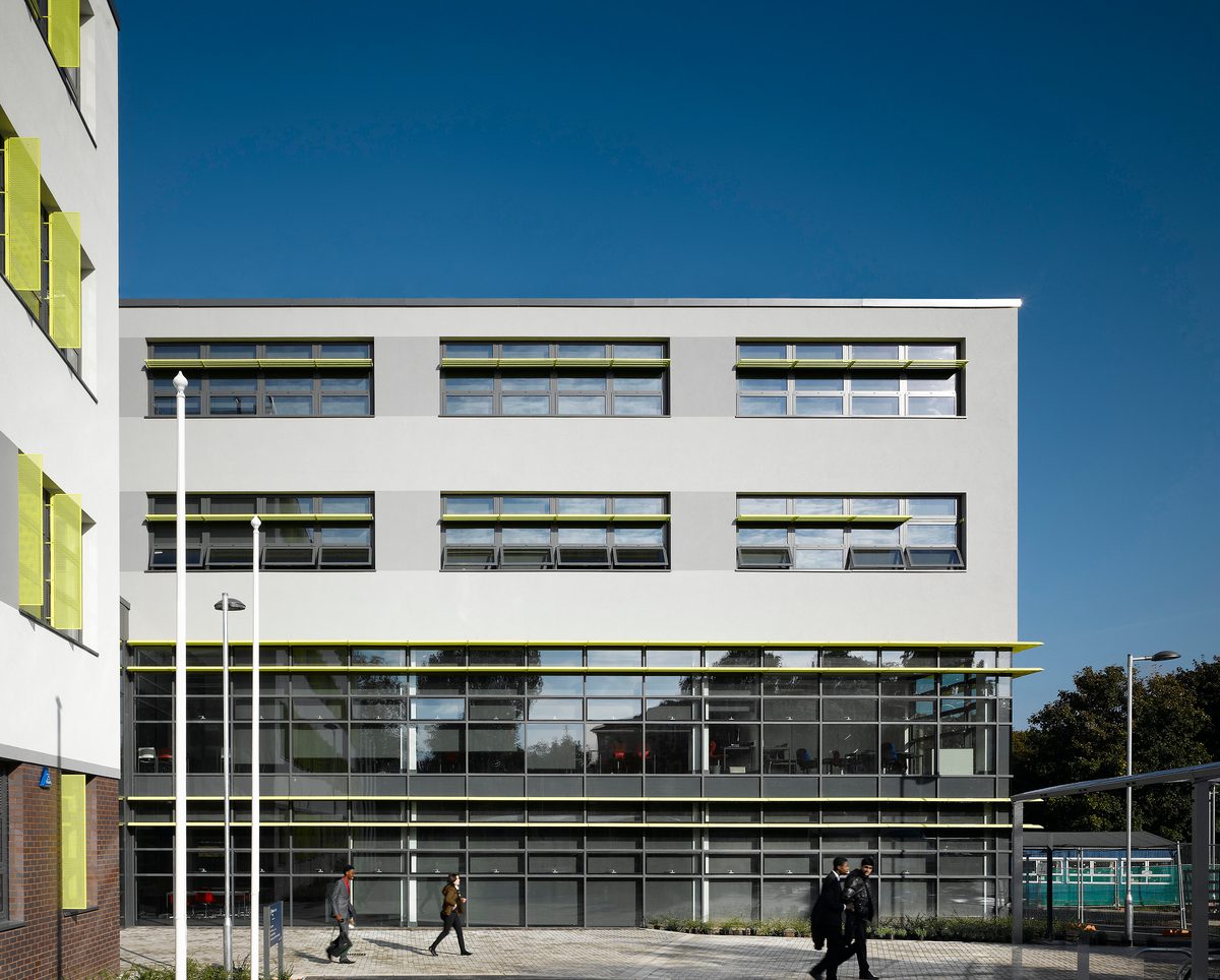 The exterior facade of one of the schools within the Harris Foundation Trust, with students walking in the foreground.