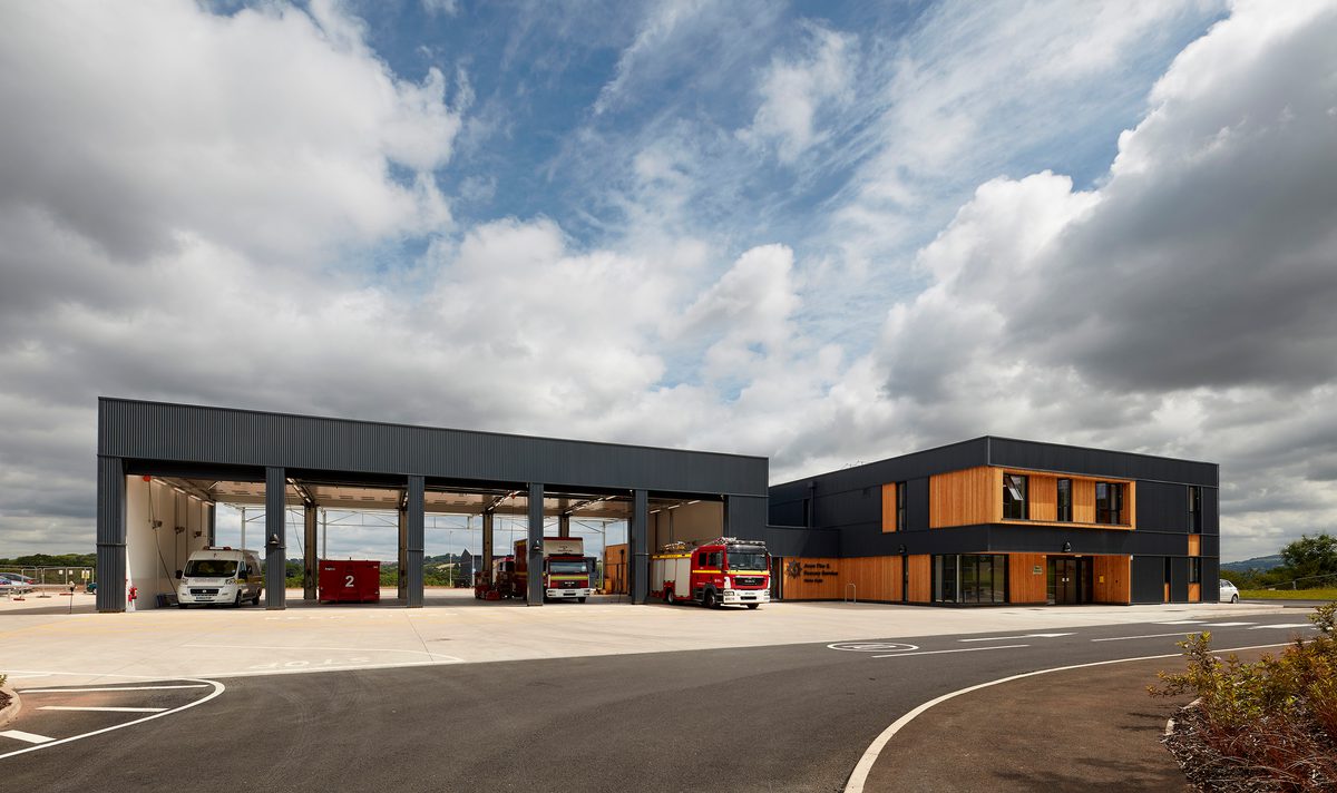 An exterior shot showing the Hicks Gate Fire Station in it's entirety, with striking grey anthracite corrugated metal cladding contrasting with bright timber.