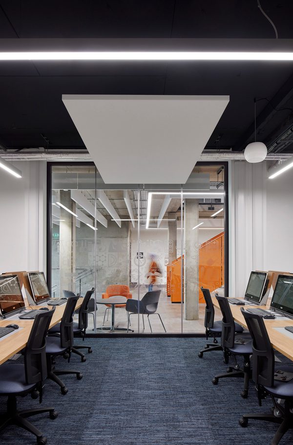 Teaching space at Joseph Priestley Building showing exposed services, acoustic ceiling panels and workstations.
