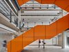 A striking orange staircase in a bright central area , with mezzanine balconies around the edge, created as part of the refurbishment works of the Joseph Priestley Building.