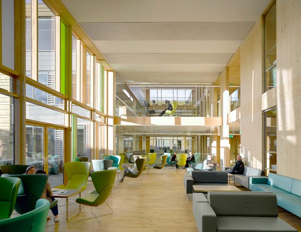 The large bright atrium within Keynsham Civic Centre and One-Stop-Shop, with double height windows, mezzanine level, wooden cladding and variety of workspaces.
