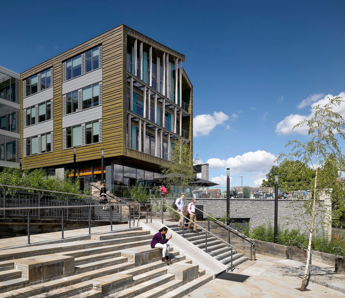 The exterior of Keynsham Civic Centre and One-Stop-Shop with people sitting on the steps in the surrounding public realm.