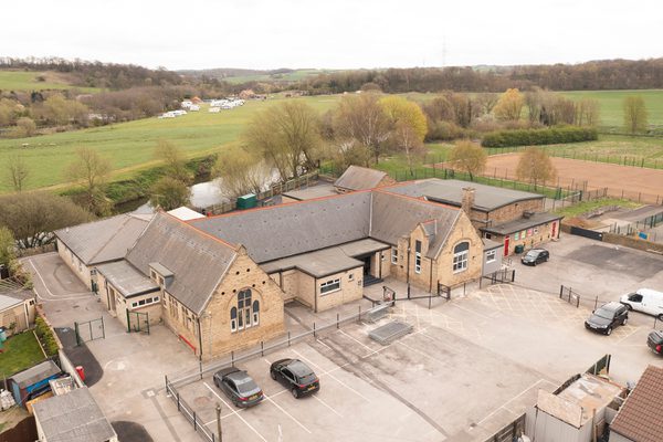 An aerial shot showing the entirety of Kilnhurst Primary School and its countryside surroundings.