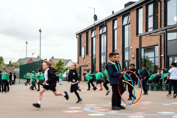 Children playing in the playground in front of Kingsbrook View Primary Academy.