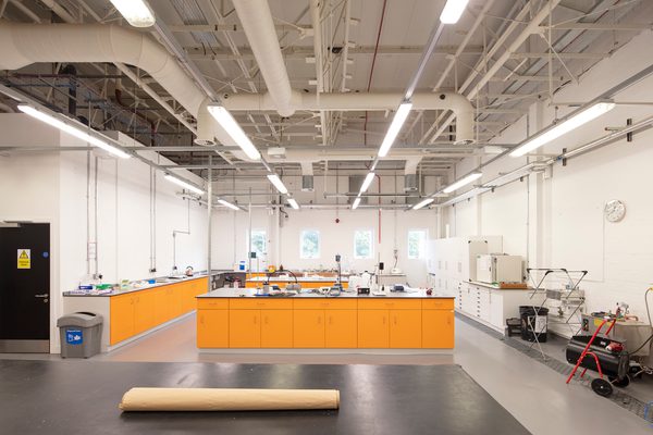 A large, bright facility within the Laura Annie Wilson Building, with kitchen and food preparation facilities and bright orange detailing.