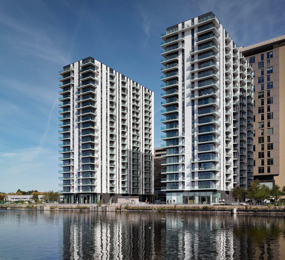 An exterior shot of the two high rise residential blocks which make up the Lightbox and The Green Rooms development, showing their waterside MediaCityUK location.