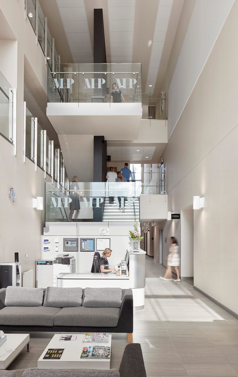The bright and welcoming central three-storey reception, with lightwell and glass mezzanine levels of the Manchester Institute of Health and Performance.