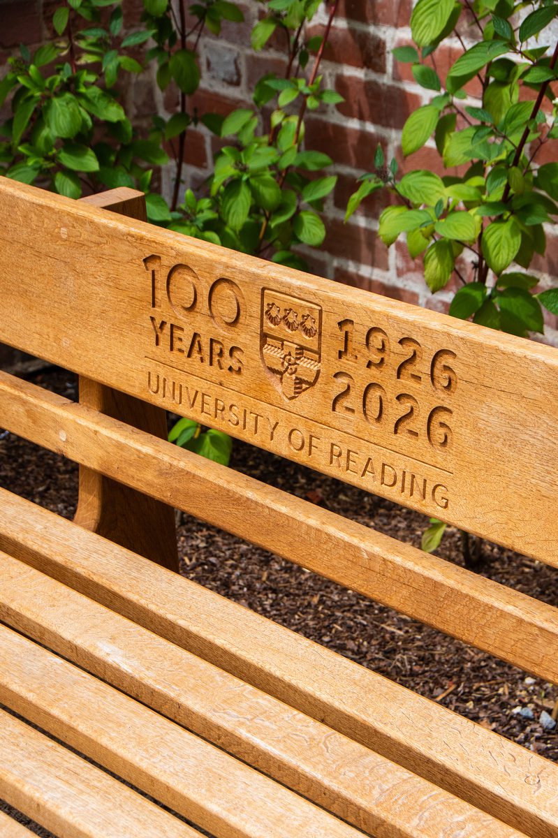 A detailed shot of an outdoor bench with an engravement marking the University of Reading's centenary.