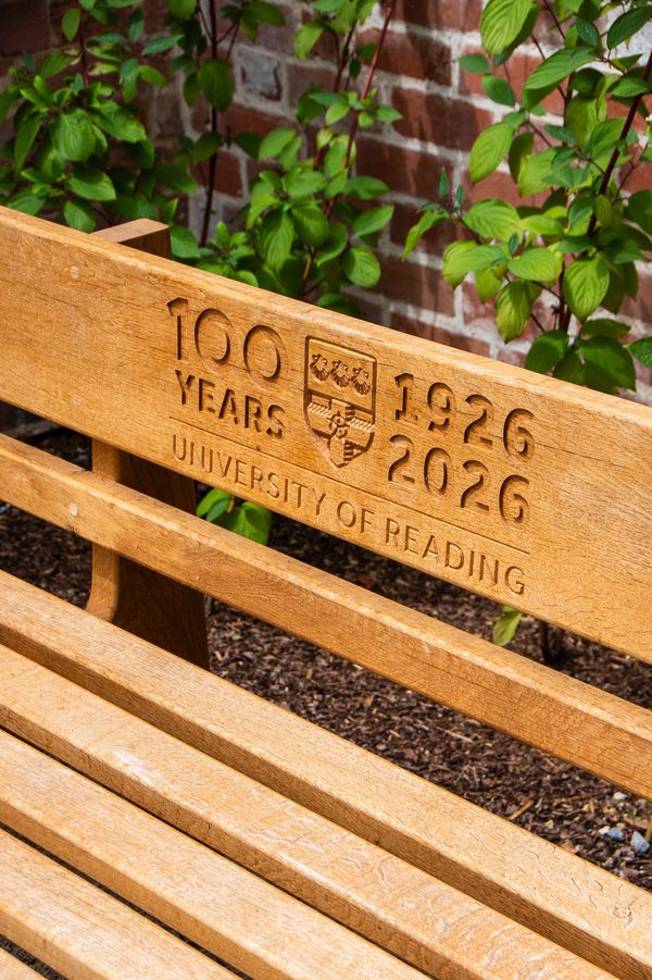 A detailed shot of an outdoor bench with an engravement marking the University of Reading's centenary.